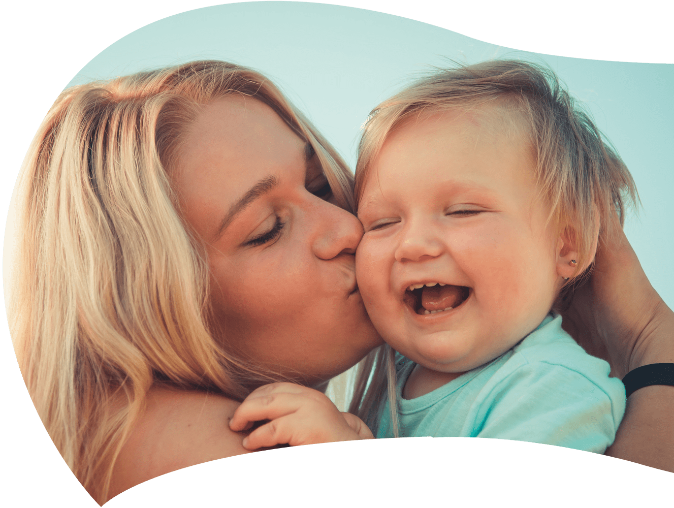 Foto de uma mãe beijando seu filho sorridente